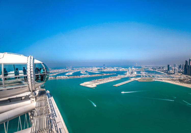 תצפית מגובה רב על גלגל הענק אֵין דובאי ואי הדקלים ברקע ביום בהיר.