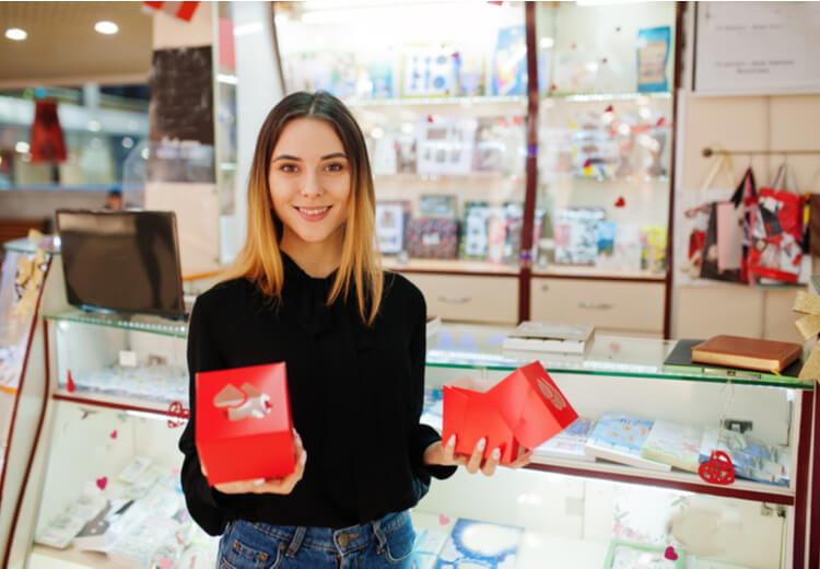 אישה צעירה מחזיקה קופסאות מתנה בחנות